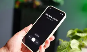 Dłoń trzyma smartfon z ekranem blokady, na którym widnieje komunikat "Nieznany numer" i numer telefonu. Warto sprawdzić numer telefonu, zanim się go odbierze.