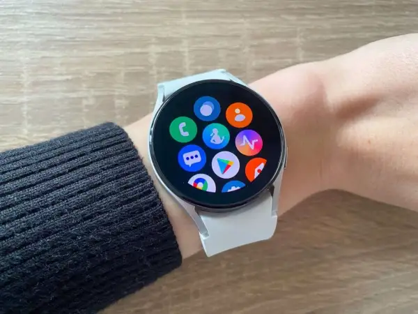 Galaxy Watch 4 z ikonami aplikacji na ekranie, gotowy do połączenia z iPhone.